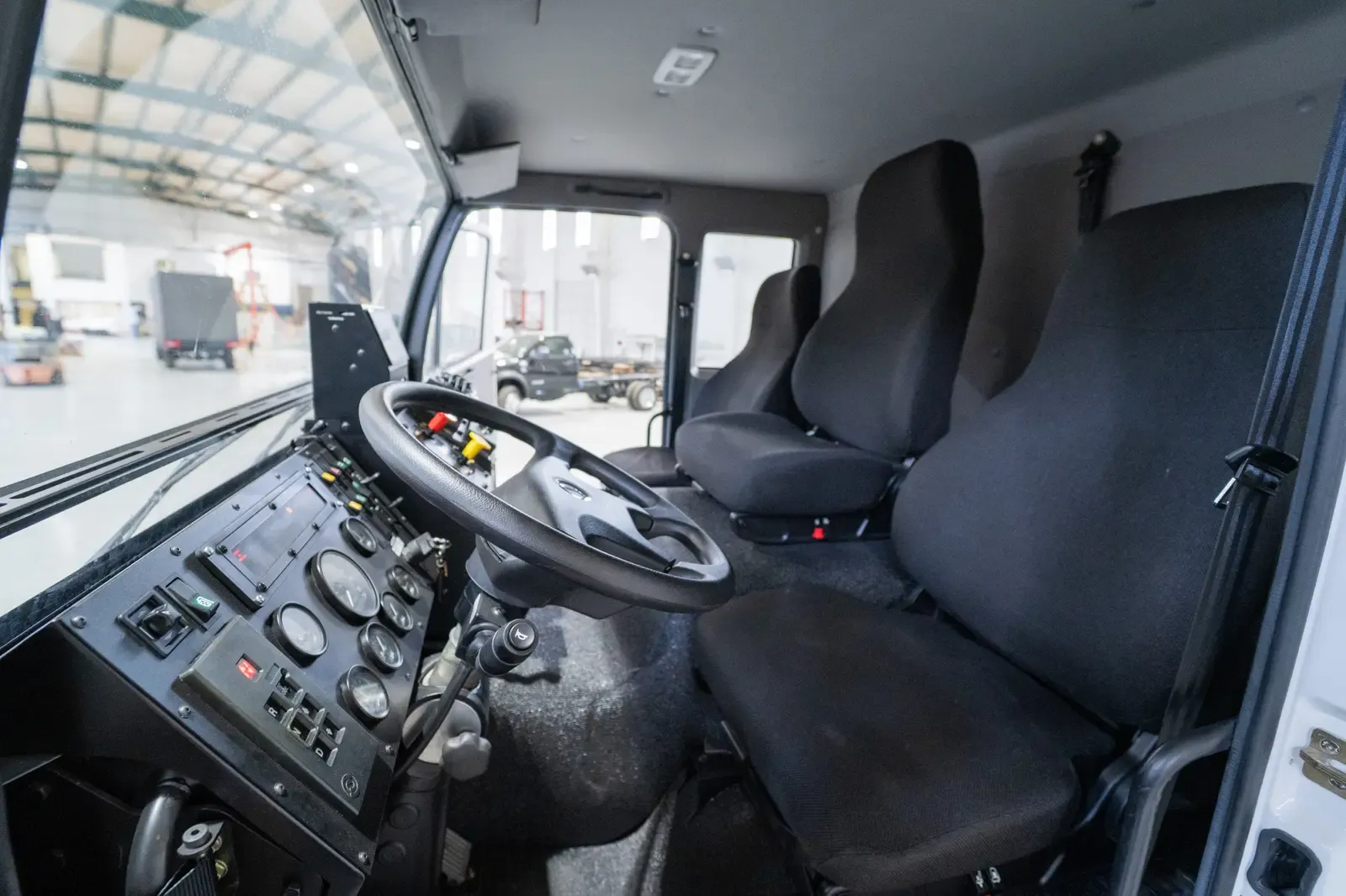 Inside the three-person cab of the Acela Monterra 6x6 — steering wheel, gauges and seats