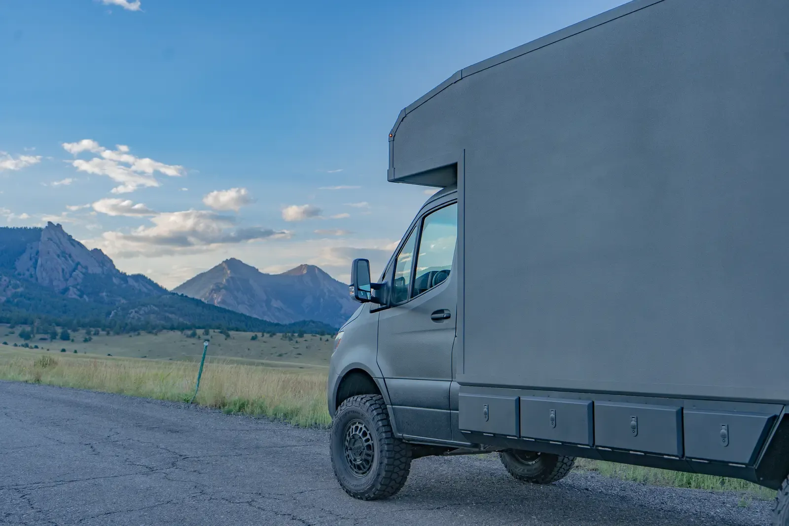 Matte-olive FV-170 demo composite camper on a Mercedes-Benz Sprinter 170, side profile at dusk with the foothills behind