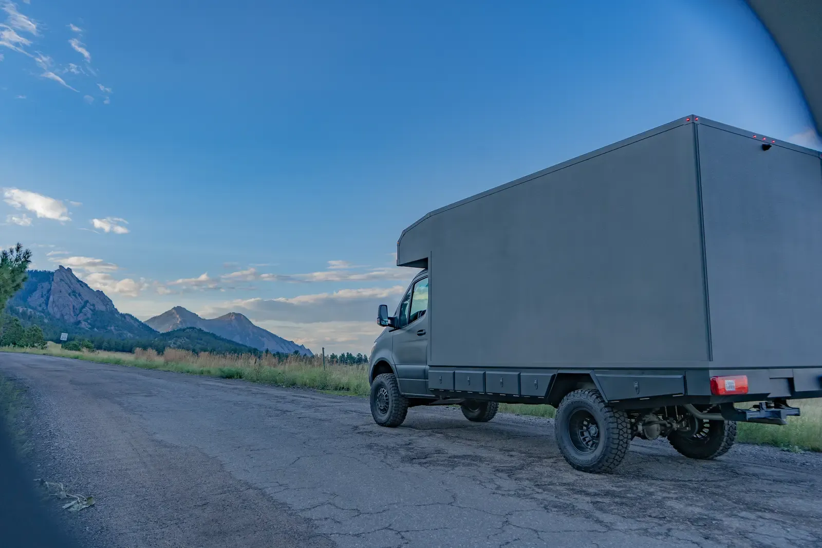 Matte-olive FV-170 demo composite camper on a Mercedes-Benz Sprinter 170, rear three-quarter view at dusk