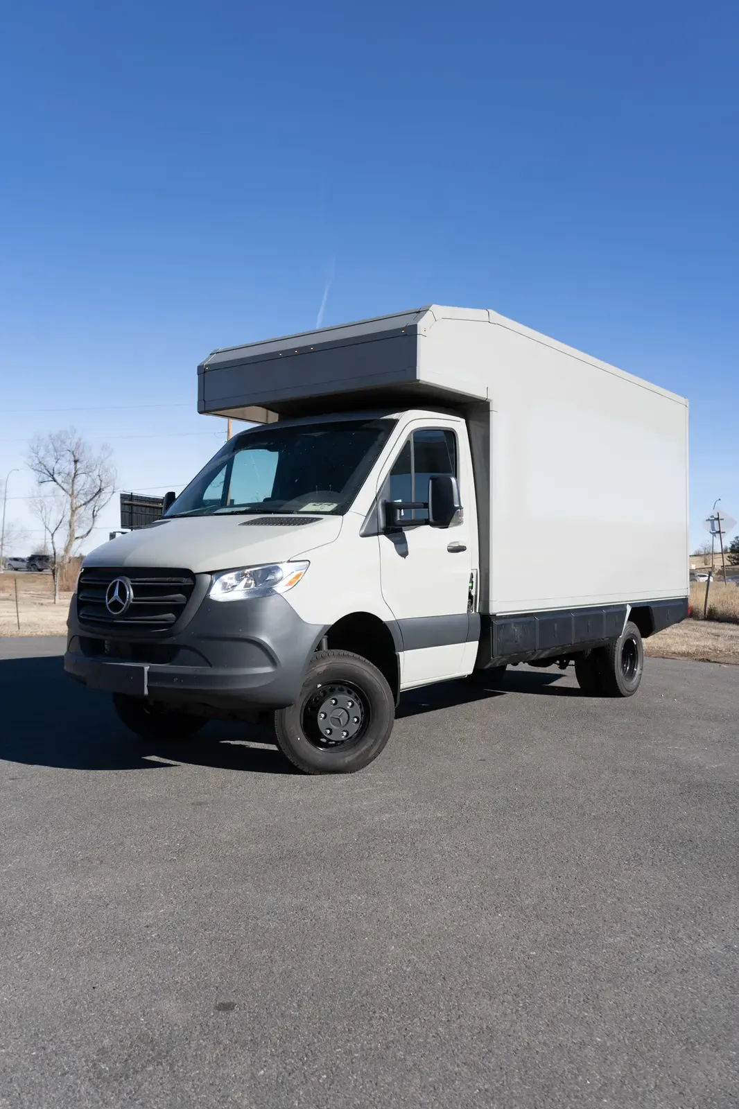 White commercial box body on a Mercedes-Benz Sprinter cab-chassis, front three-quarter view