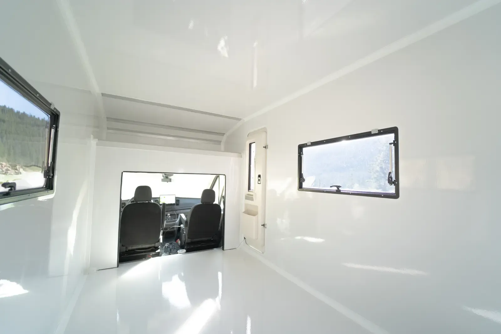 Inside the Transit's bright white composite body, with awning windows along both walls