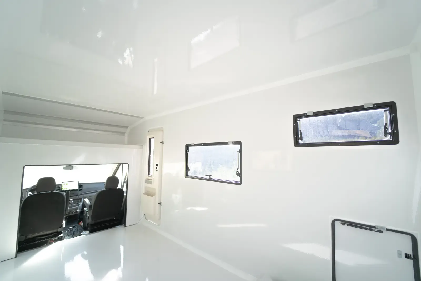 Inside the Transit's empty white composite body, showing the seamless walls and glossy floor