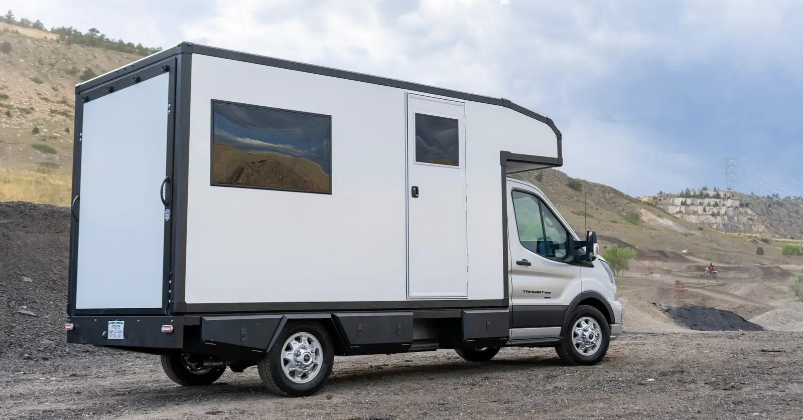 White composite RampDeck body on a Ford Transit 156, rear three-quarter view showing the full-height rear wall closed and flush