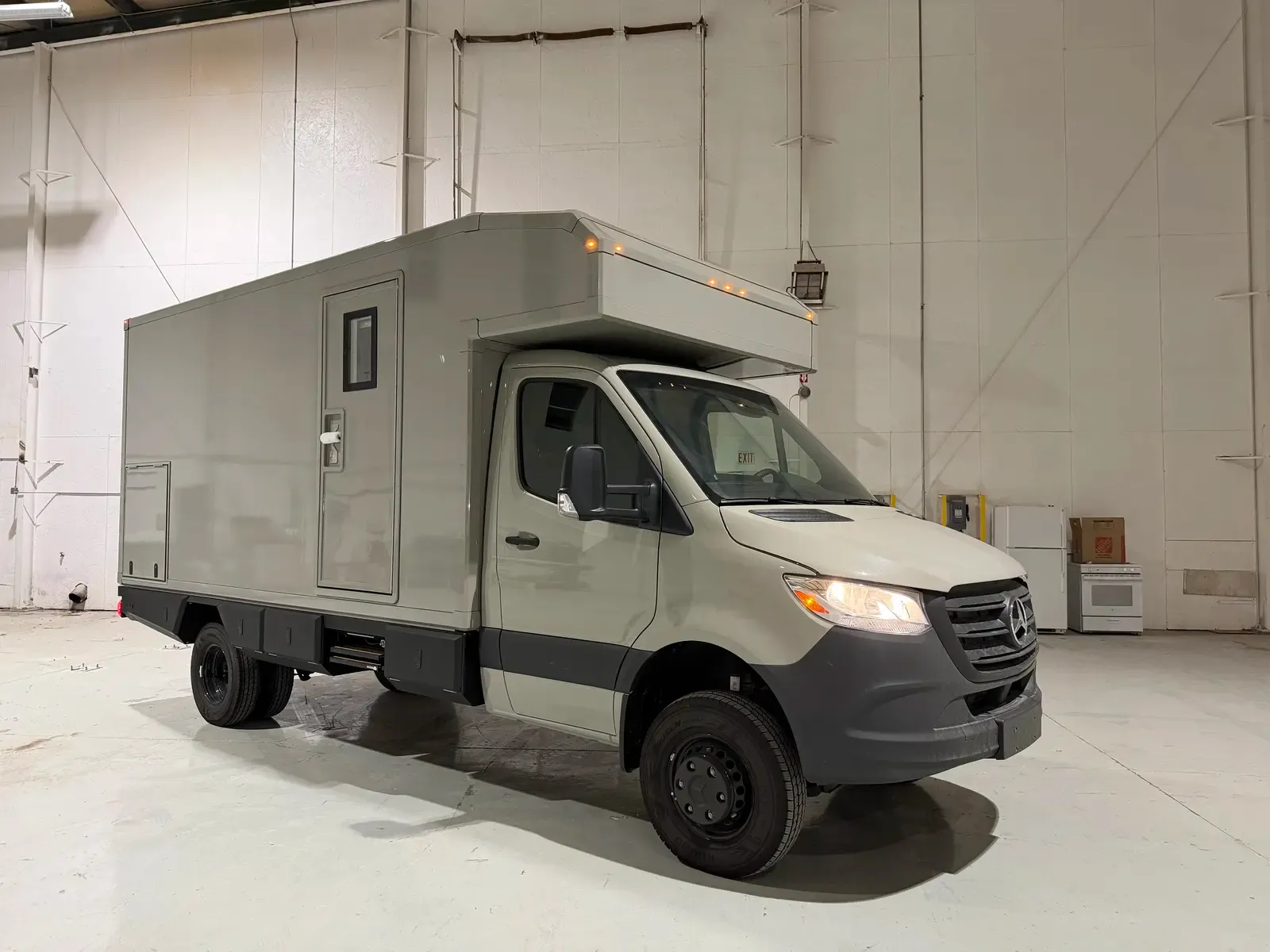 Grey commercial box body on a Mercedes-Benz Sprinter cab-chassis, side profile showing the full composite body