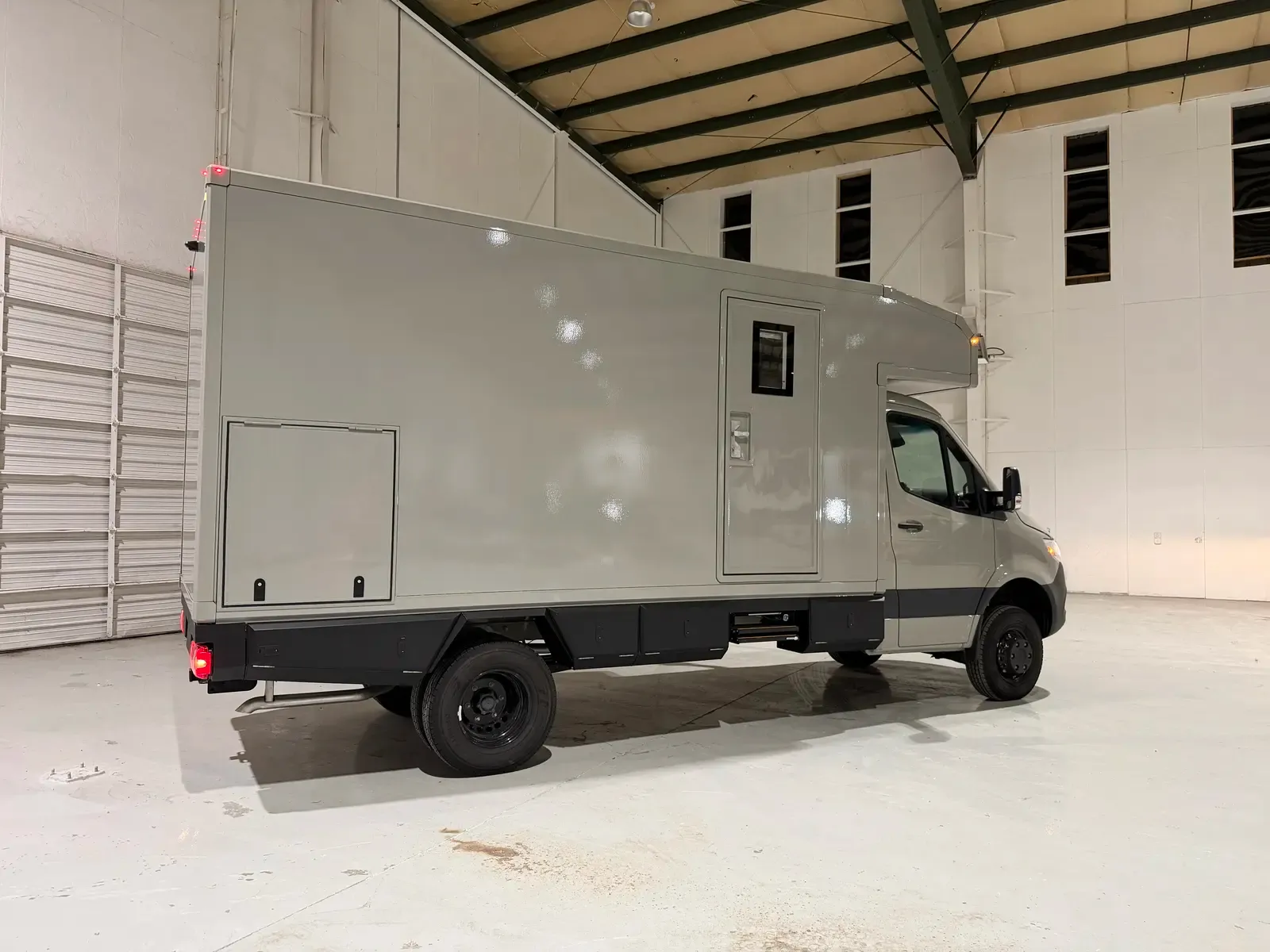 Grey commercial box body on a Mercedes-Benz Sprinter cab-chassis, rear three-quarter view