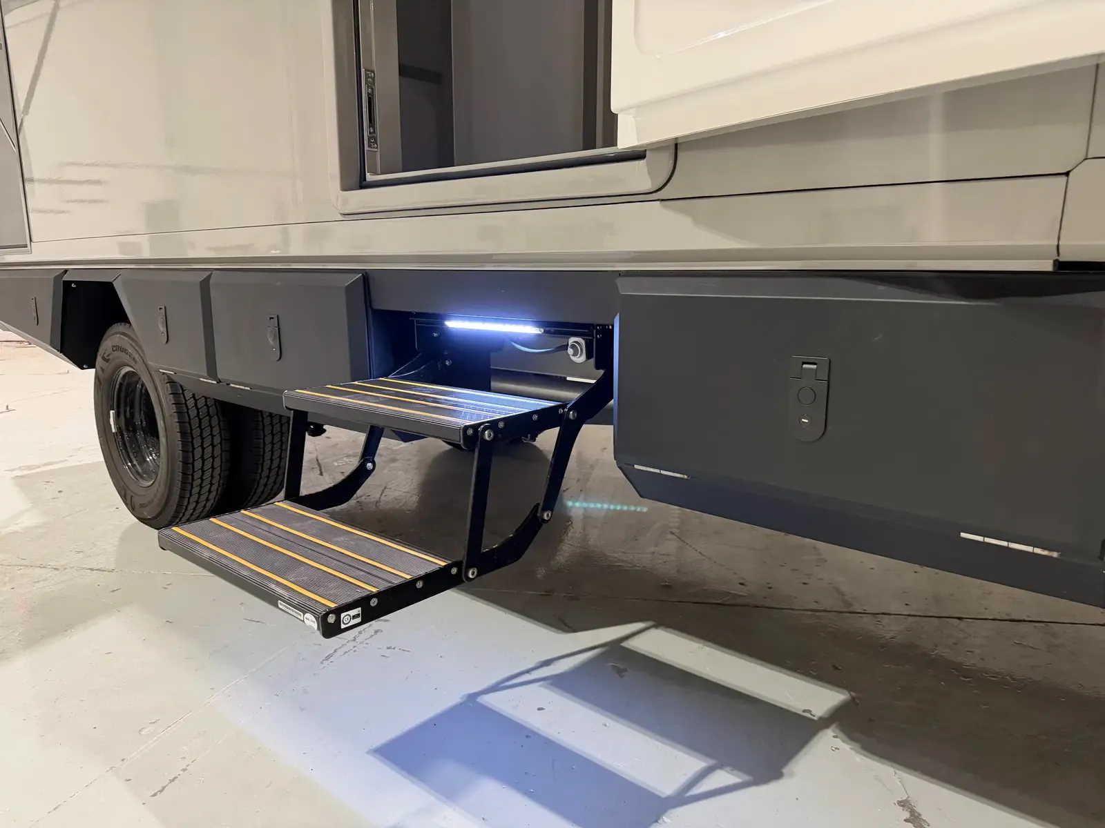 The composite body's fold-down rear access step with an integrated light