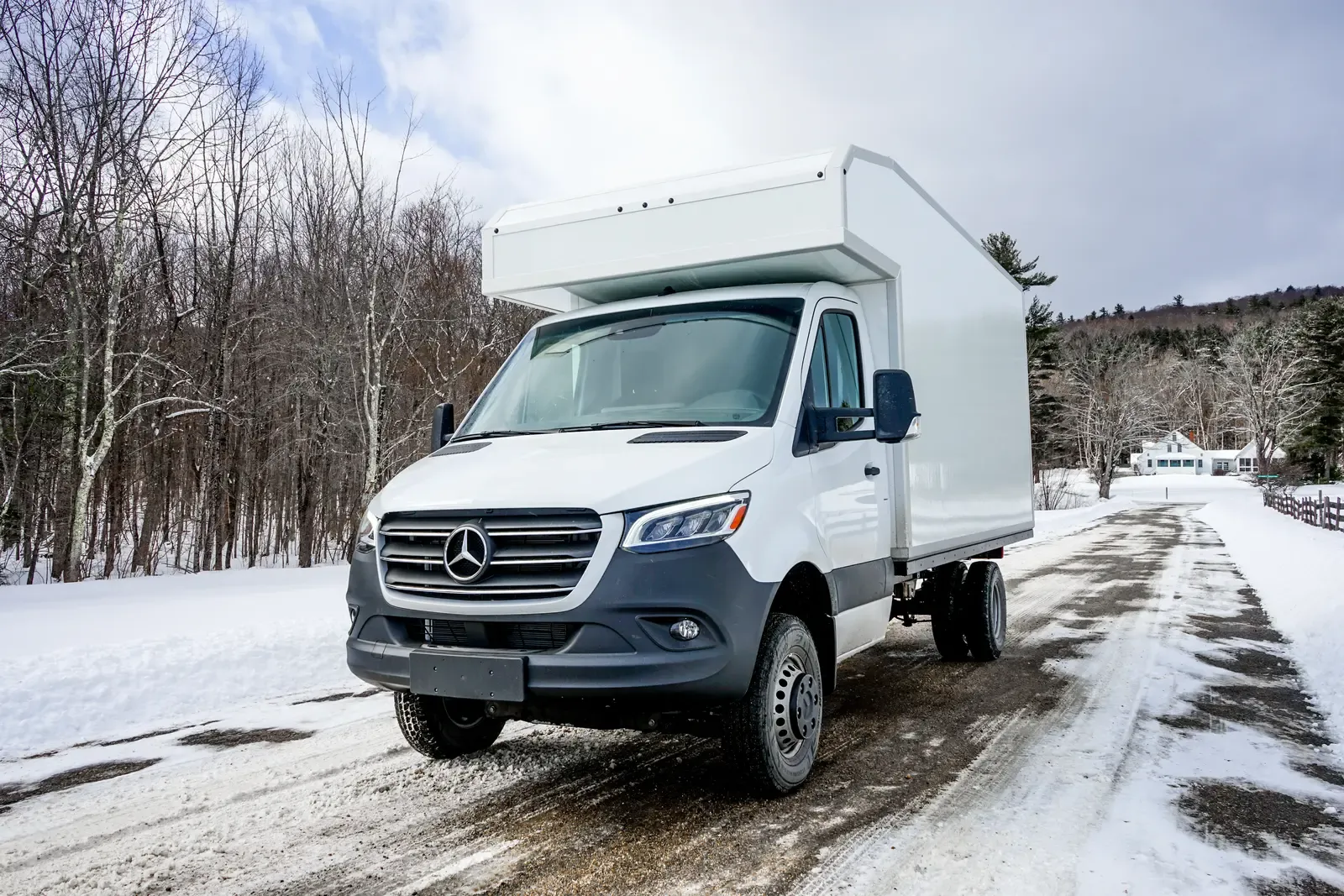 White composite box camper on a Mercedes-Benz Sprinter 170, head-on view on a snowy forest road
